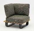 A modern armless lounge chair with a dark patterned cushion and backrest, set on a wooden base with dark metal sled legs.